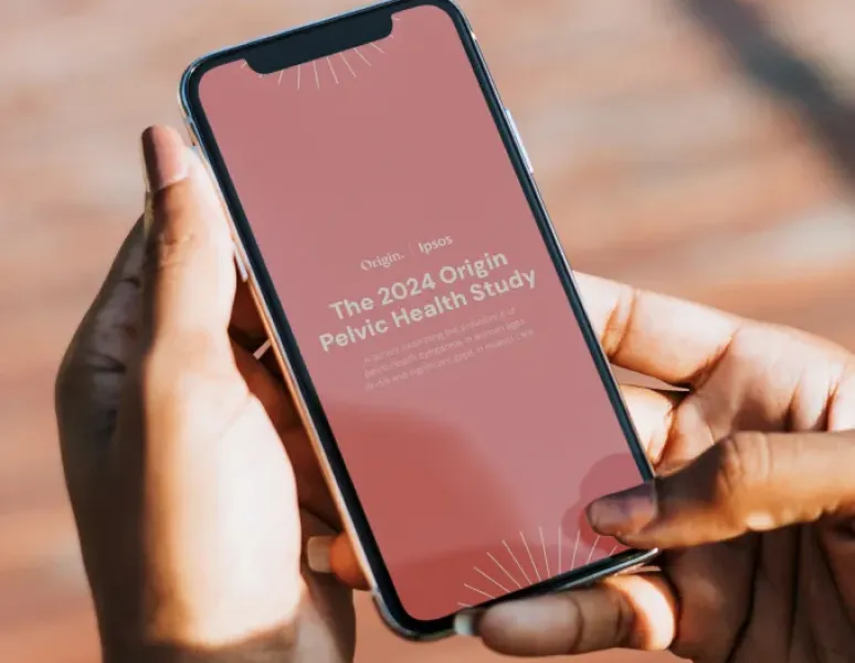 A woman reading the 2024 Origin Pelvic Health Study on her mobile phone.