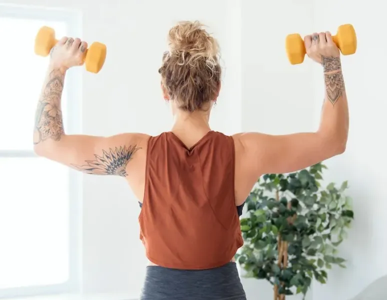 A woman in perimonopause lifting weights.