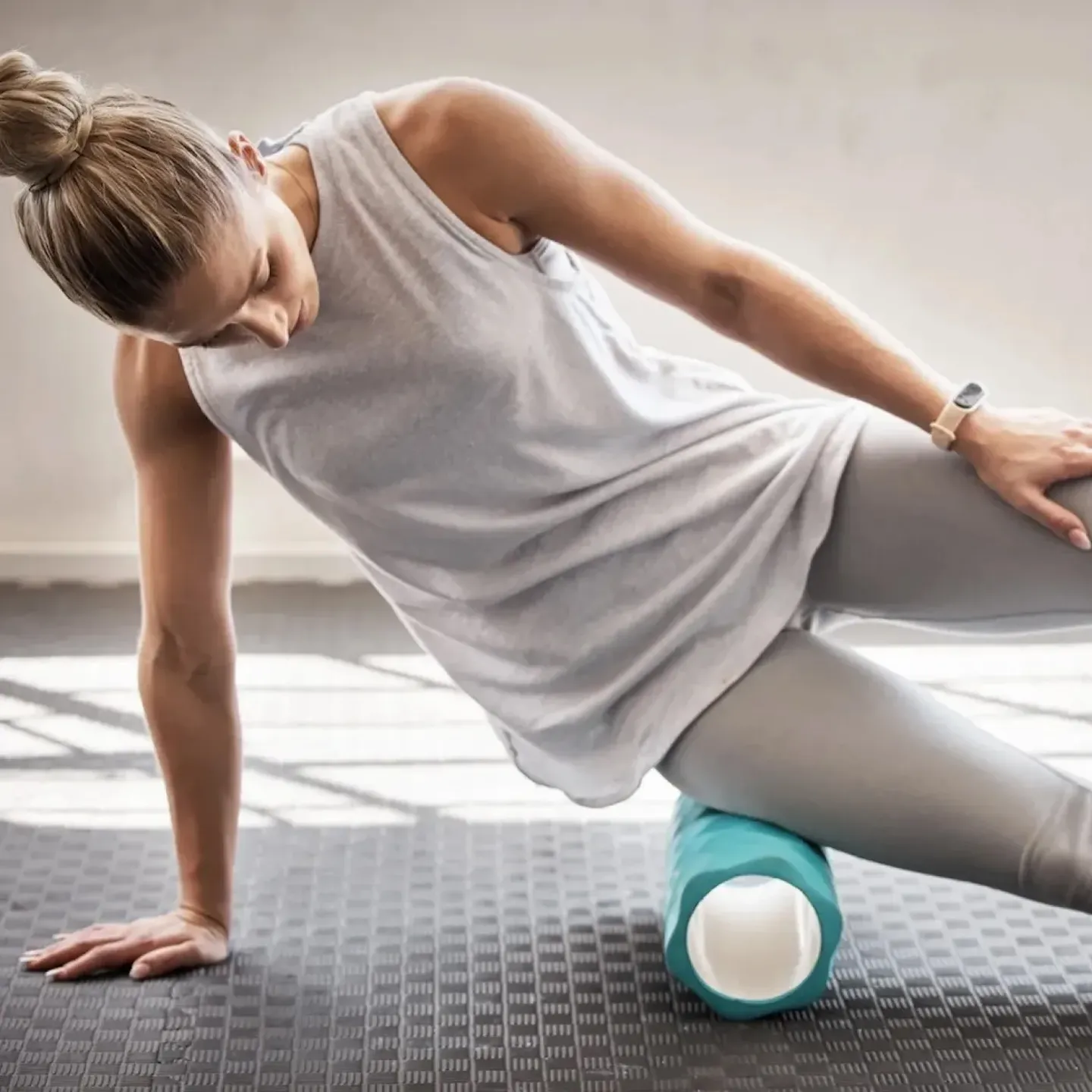 A woman foam rolling her hip in a women's health physical therapy office.