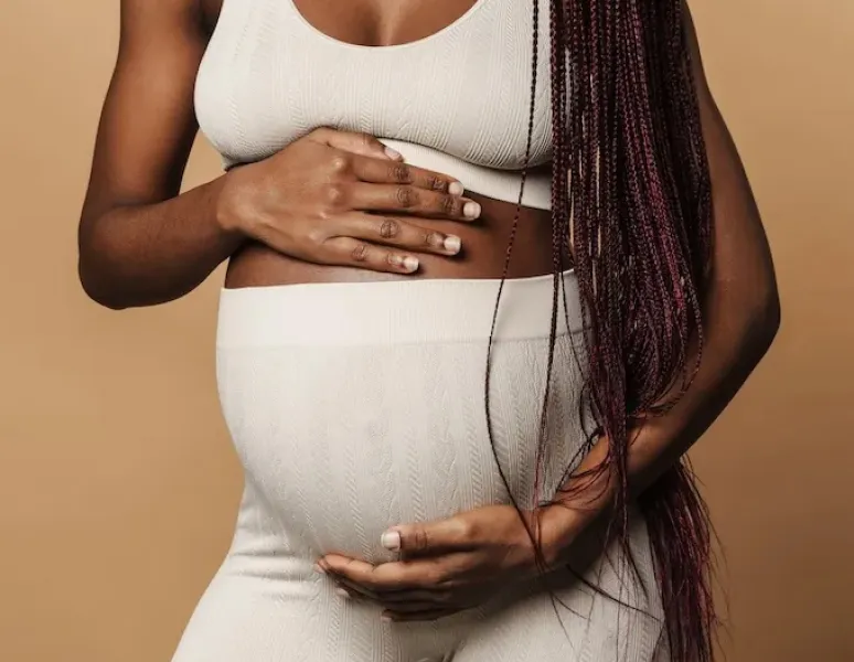 A pregnant woman whose pelvic floor is about to go through the strain of labor and childbirth.