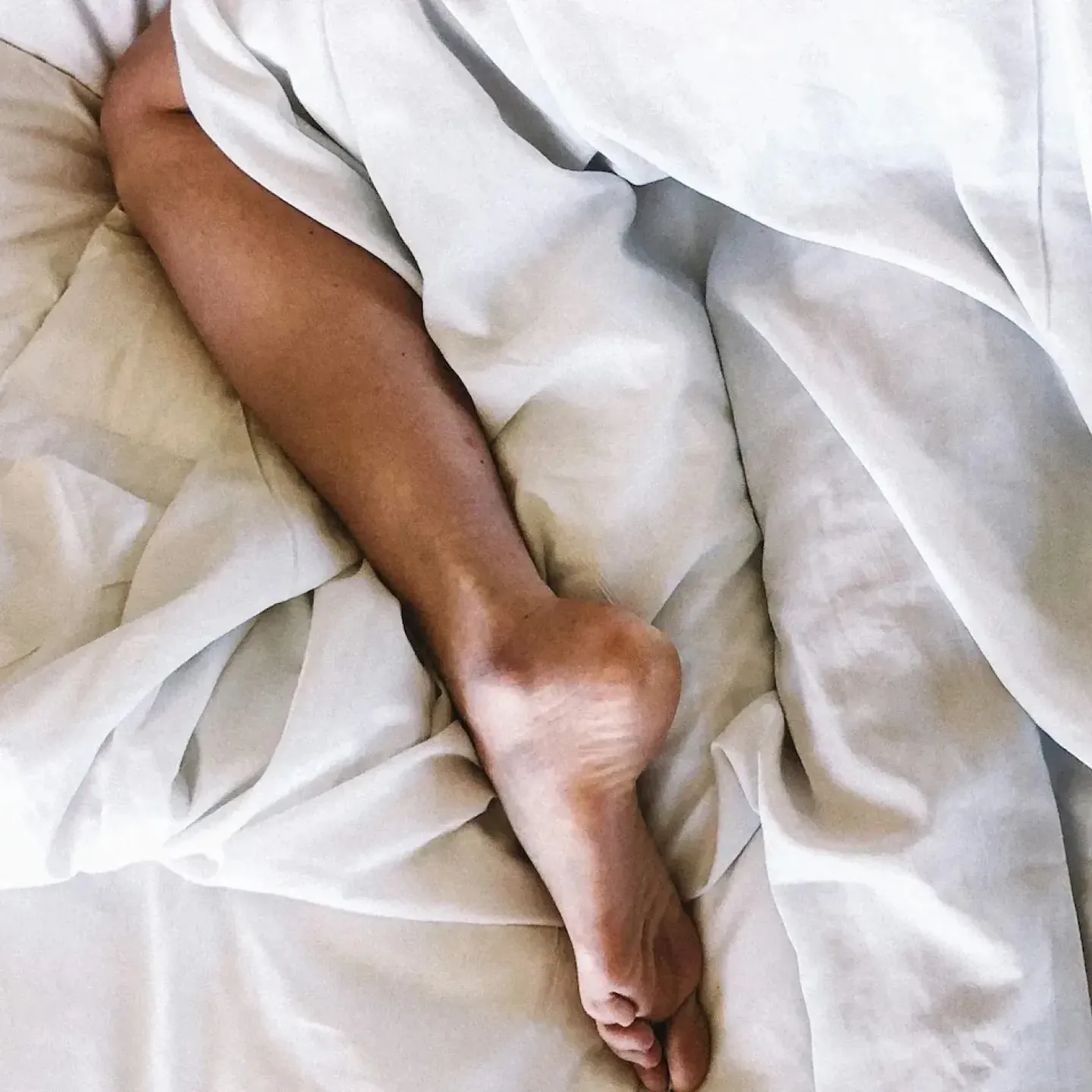 A woman with uterine prolapse lying in bed wondering if it's safe to have sex.