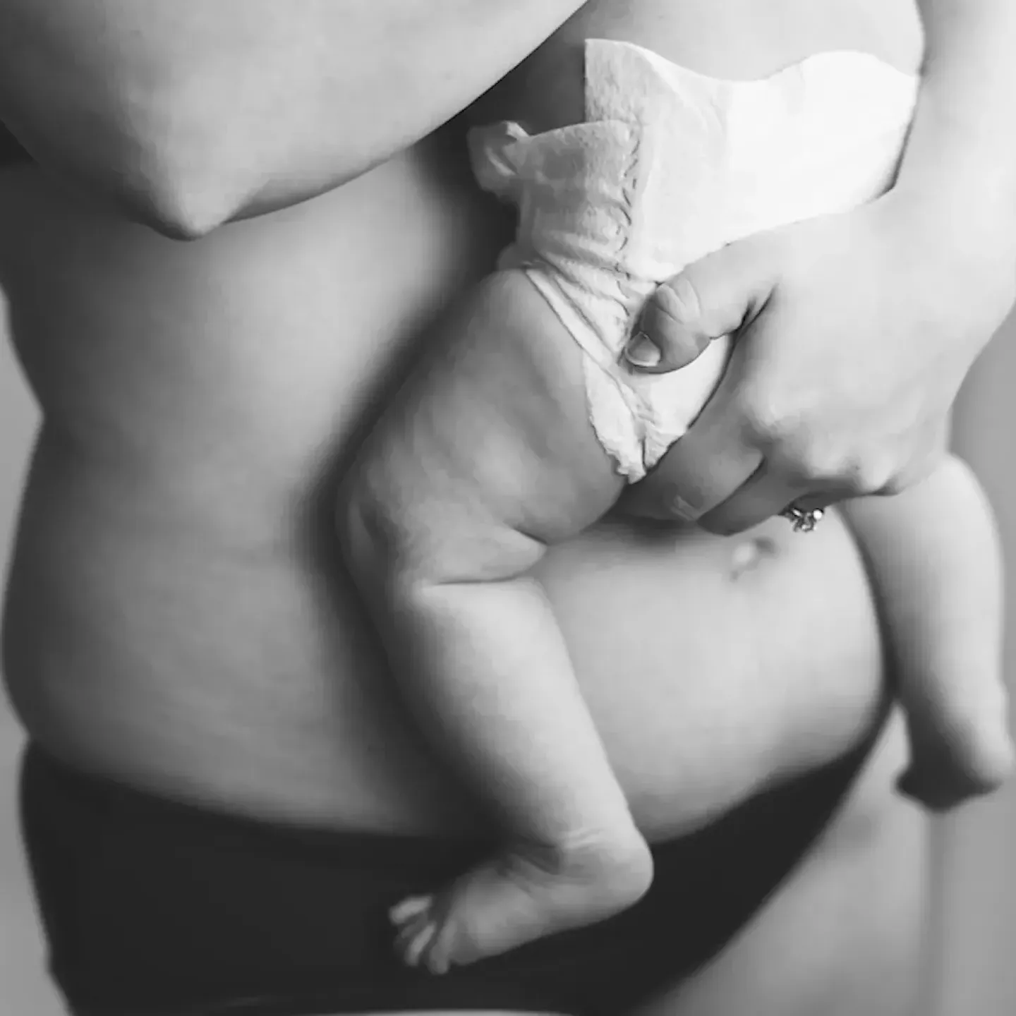 A constipated postpartum mom holding a baby.