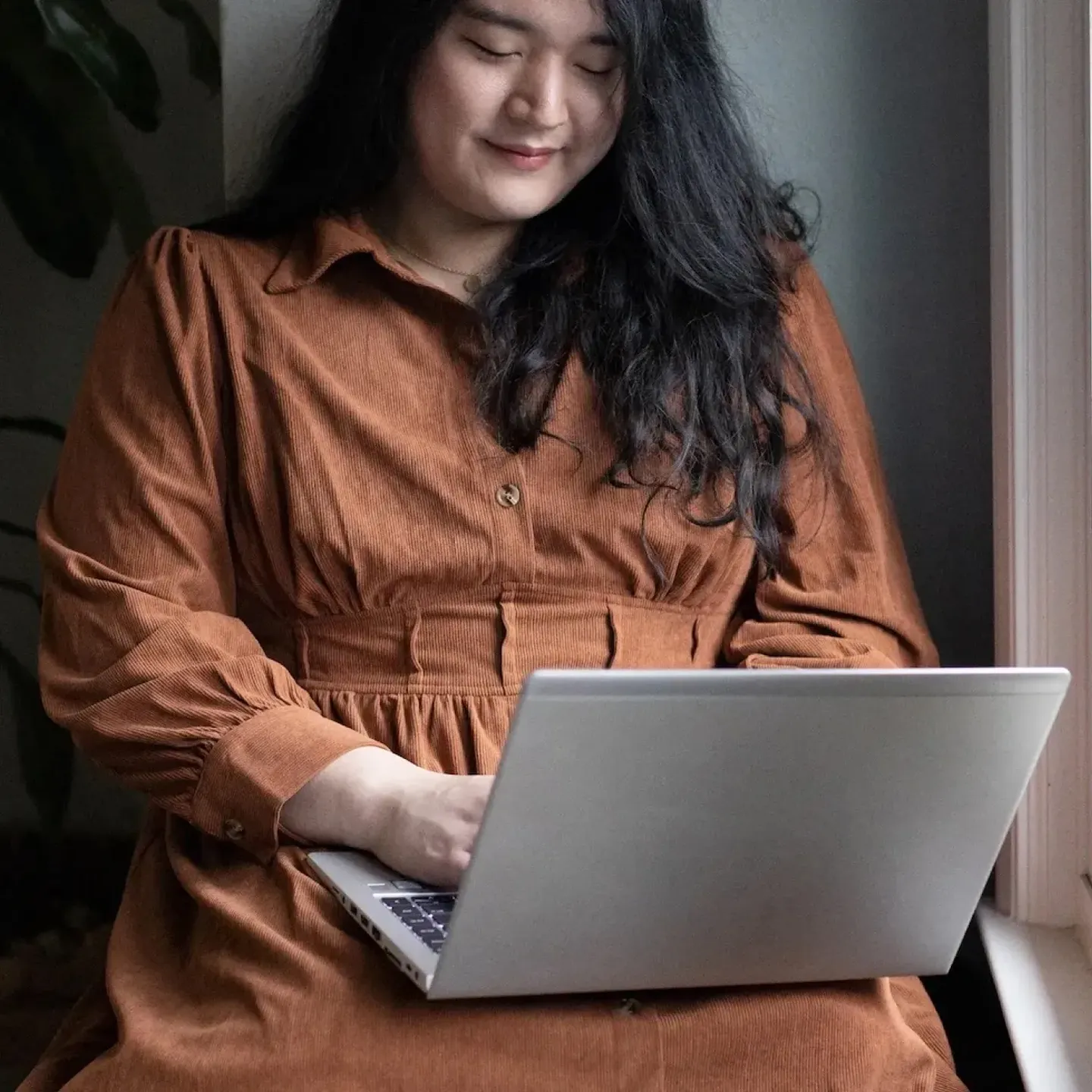 A trans, non-binary person looking for pelvic floor PT on their laptop.