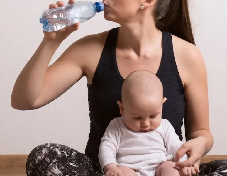 A mom with postpartum rib pain sitting with her baby on her lap.