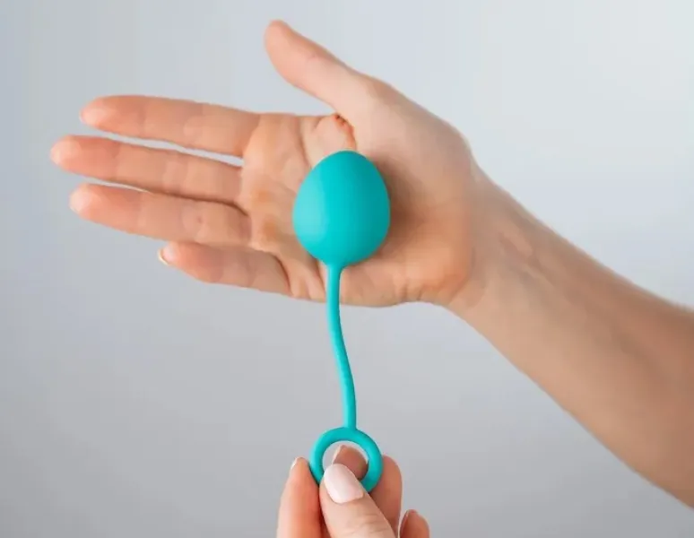 A kegel ball in the palm of a woman's hand.
