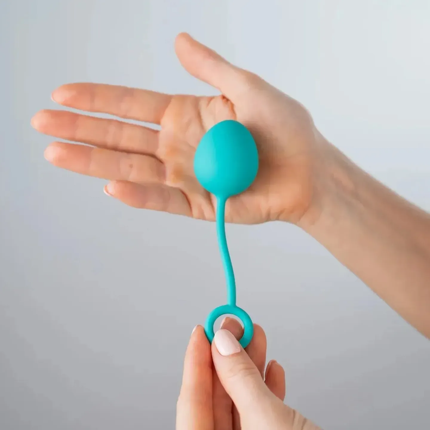 A kegel ball in the palm of a woman's hand.