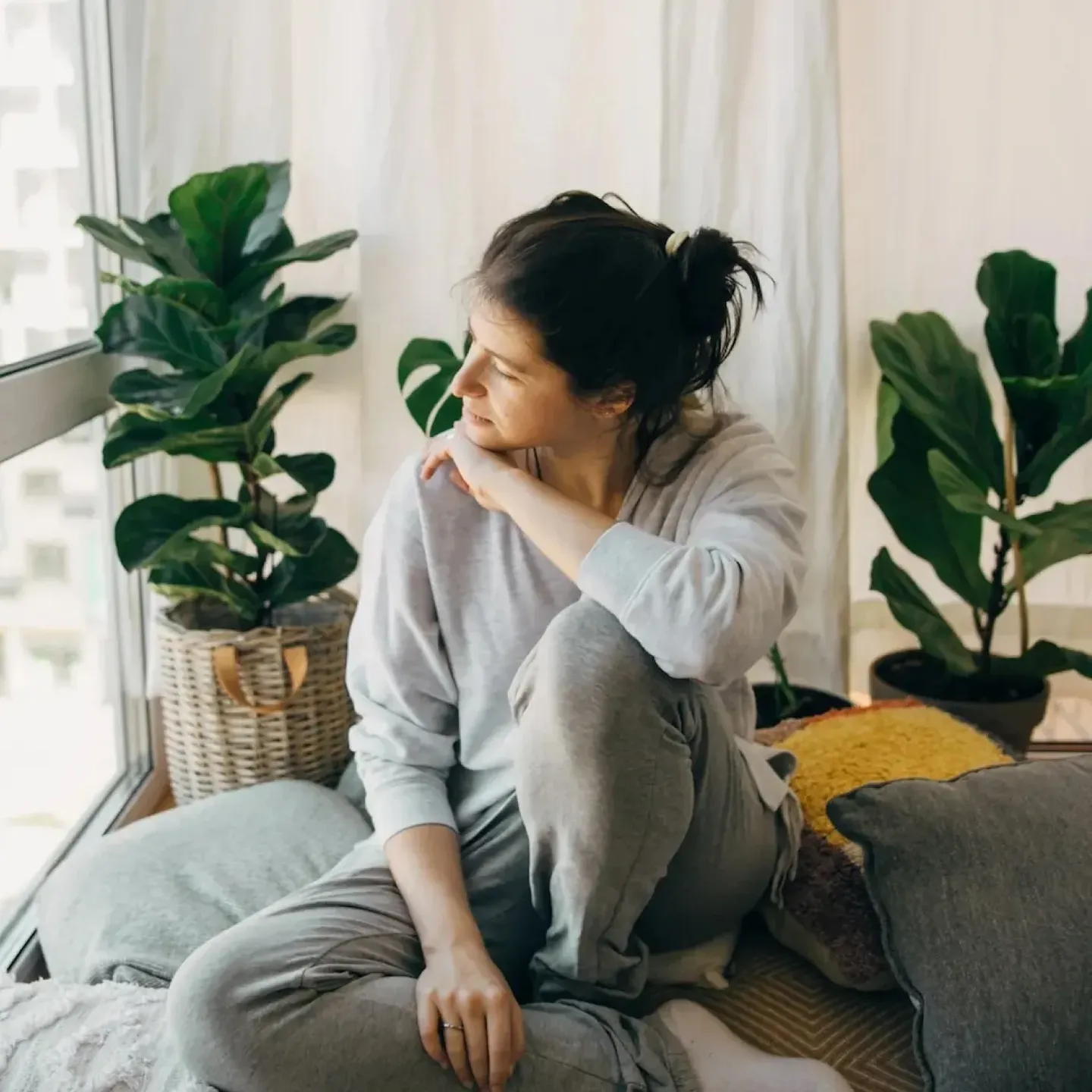 A woman sitting and staring out the window for a story on medical gaslighting and pelvic pain.