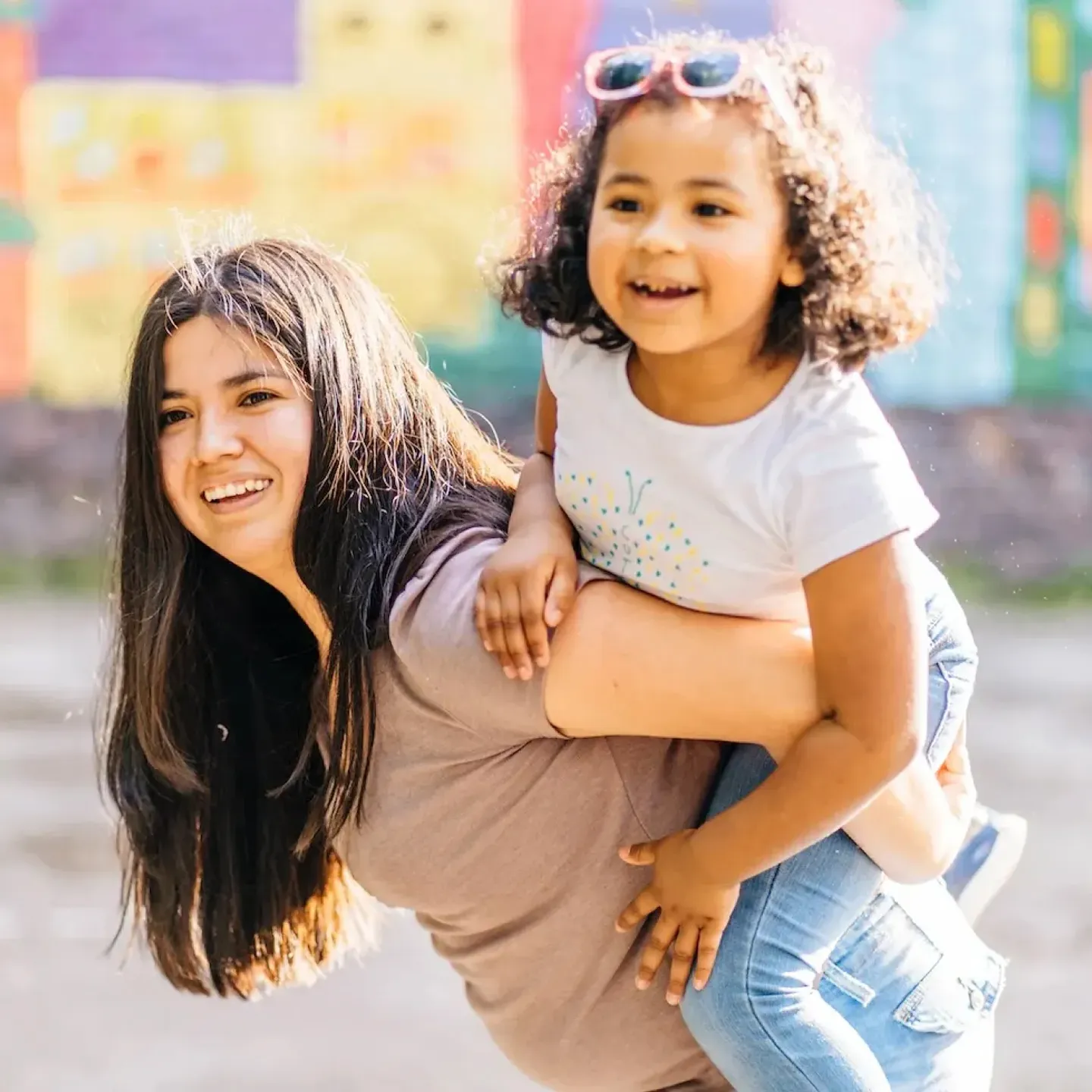 A woman with MSK issues carrying her school age daughter on her back.