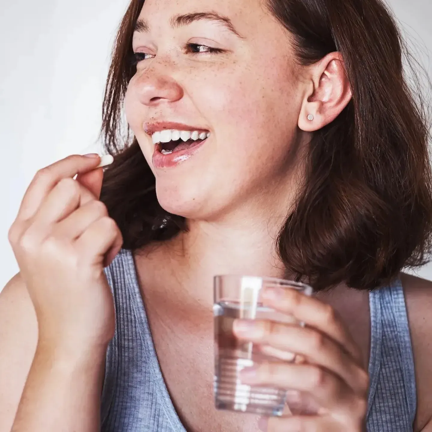A young woman taking a birth control pill.