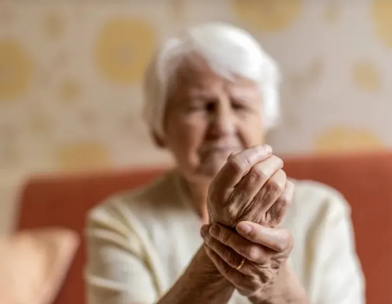 Senior woman holding her sore wrist.