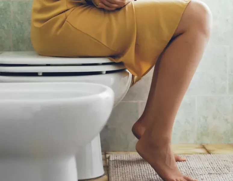 Woman sitting on the toilet symbolizing frequent urge to urinate requiring bladder training.