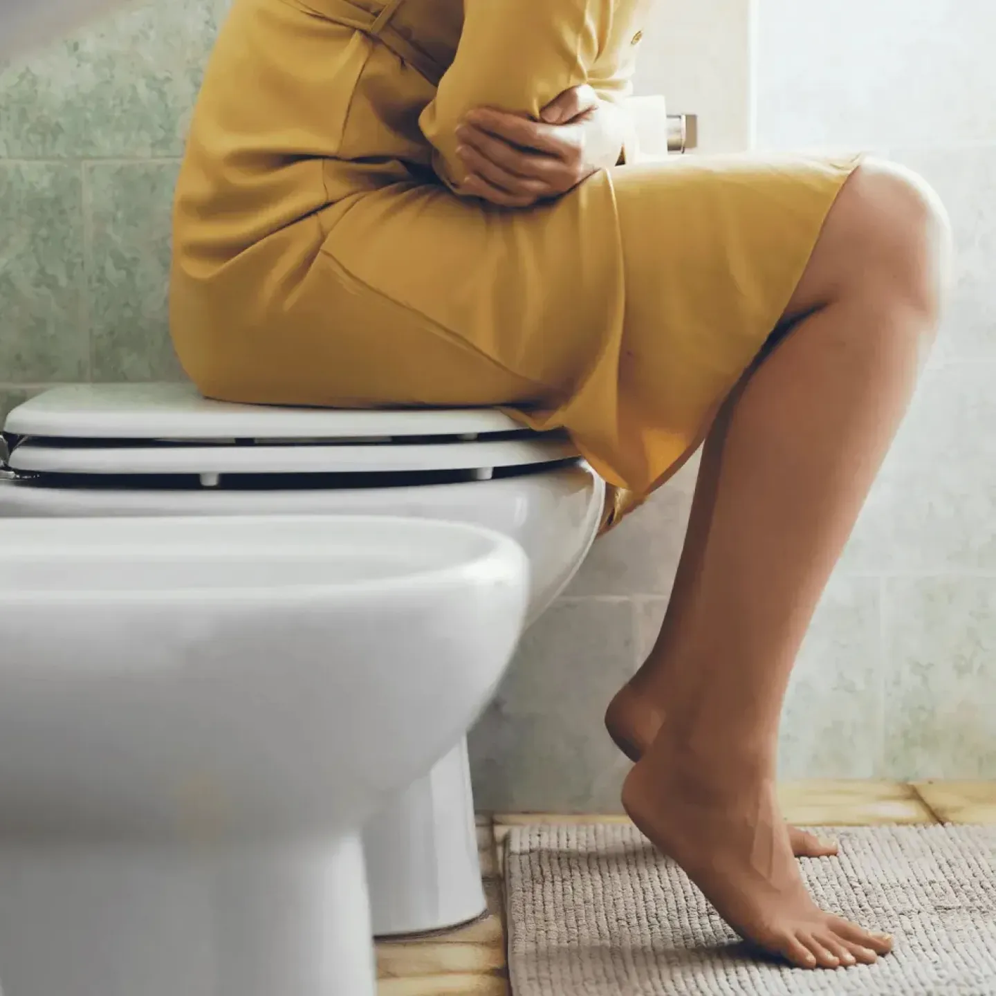 Woman sitting on the toilet symbolizing frequent urge to urinate requiring bladder training.