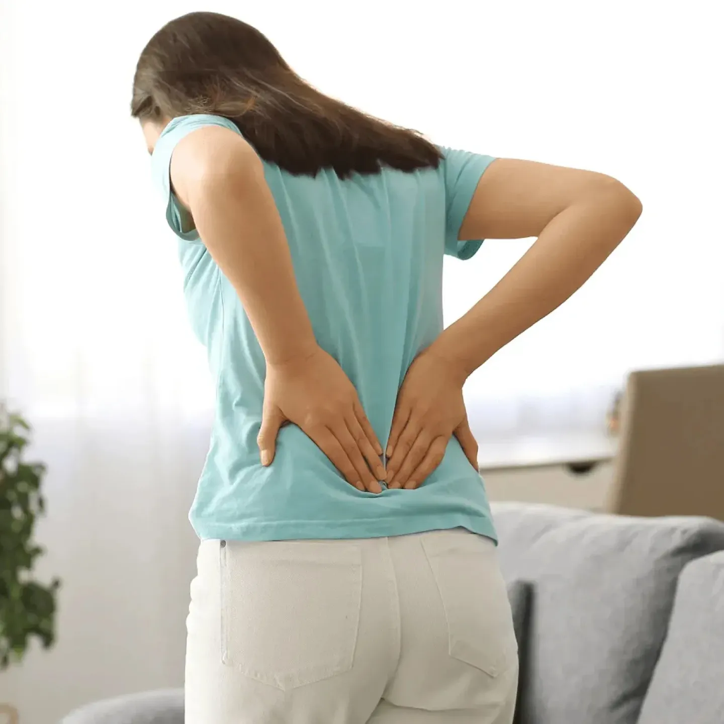 Woman holding her back symbolizing musculoskeletal pain.