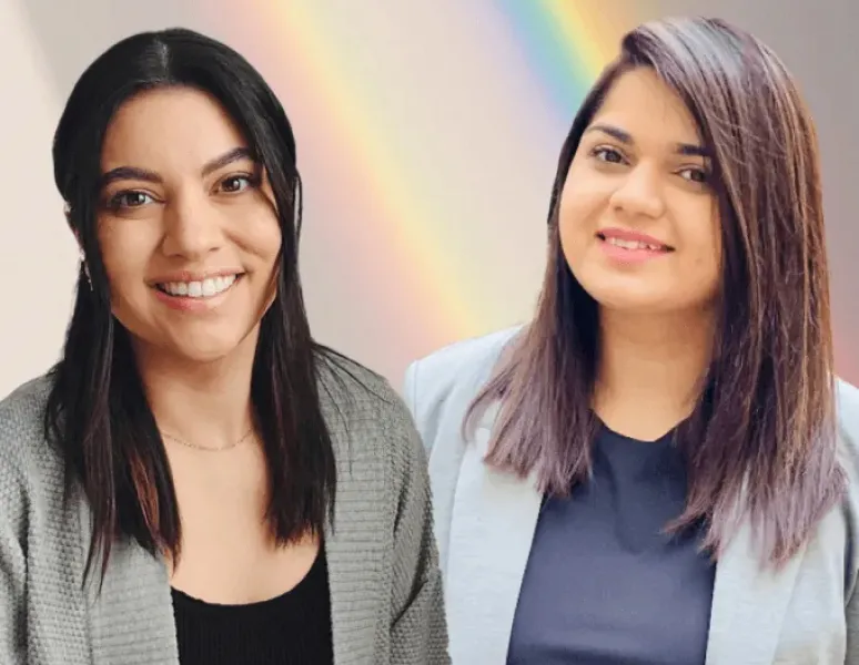 Origin Physical Therapists Dr. Vanessa Amezquita, PT, DPT and Dr. Paaneri Jethwa, PT, DPT with a rainbow in the background in celebration of Pride 2025.