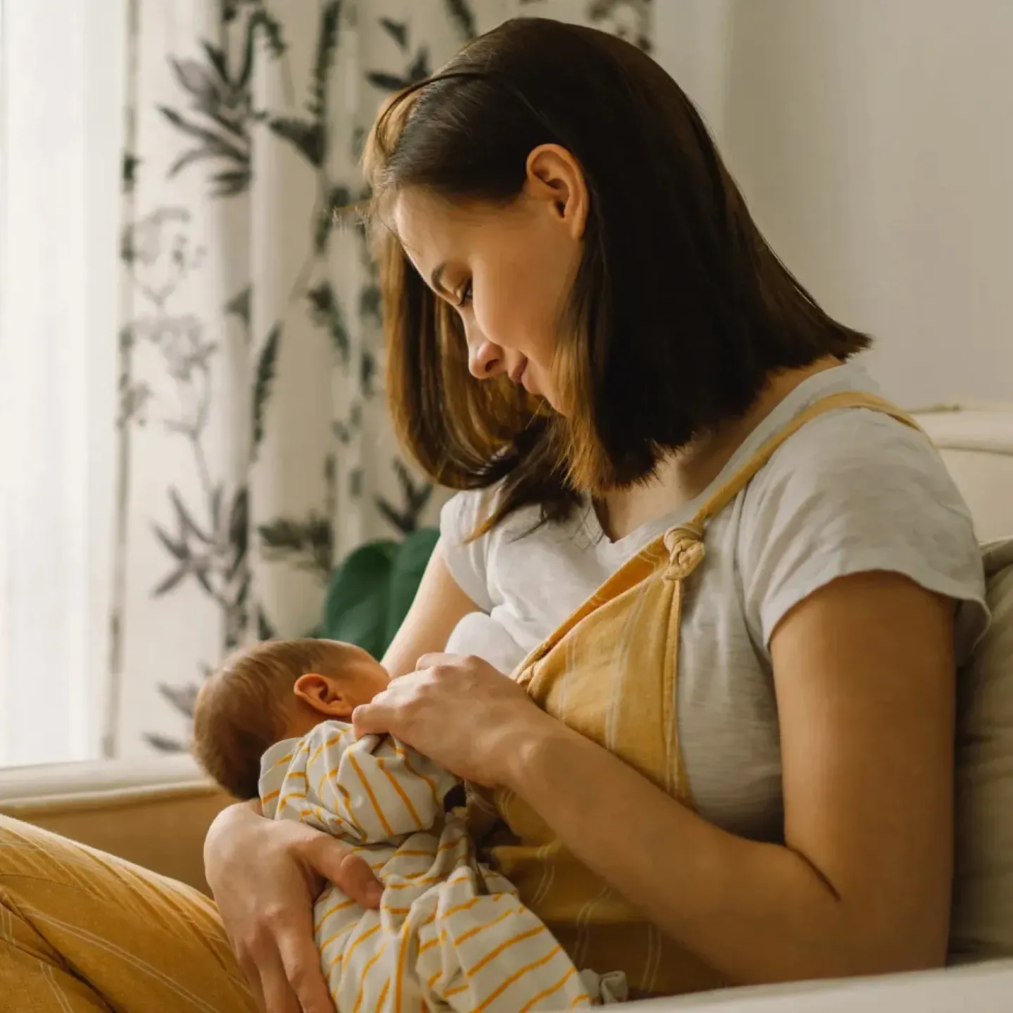 Lactating woman breastfeeding a newborn baby using an IBCLC recommended hold.