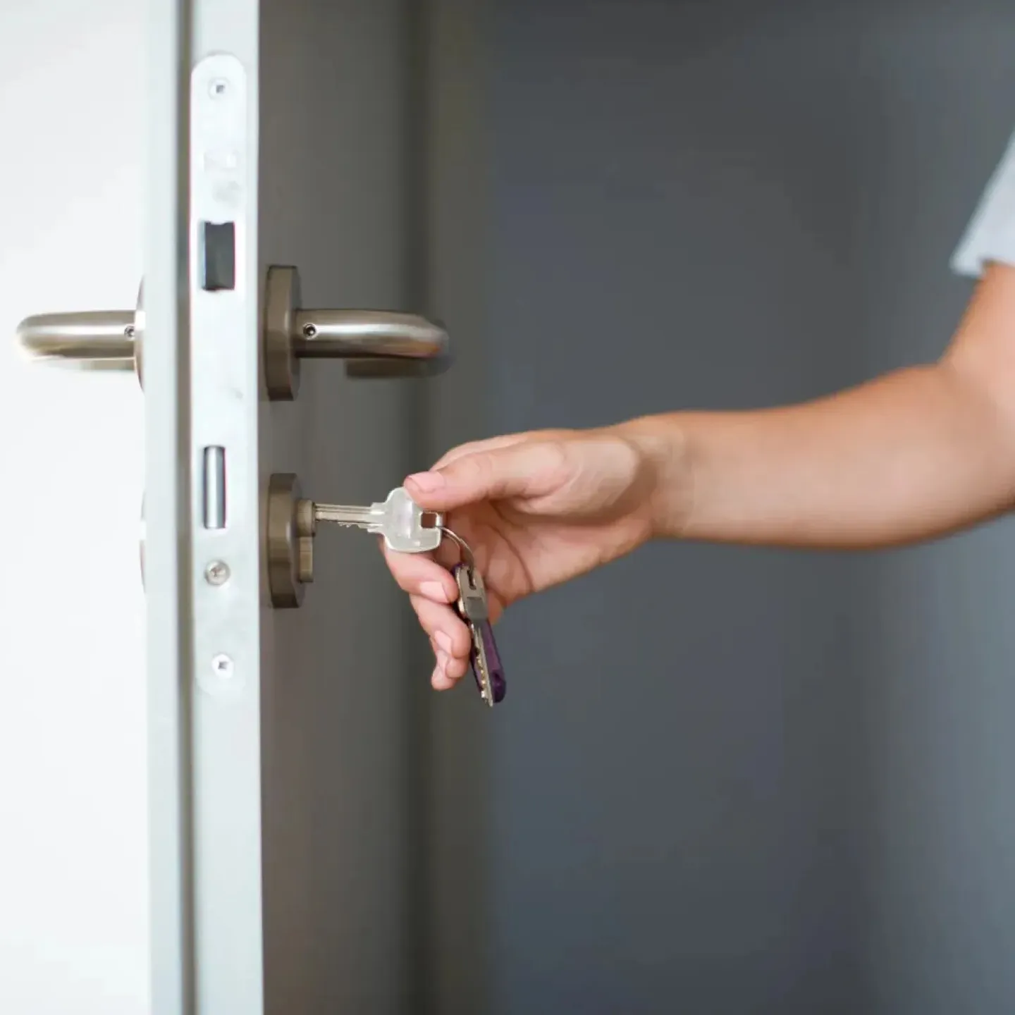 Woman with latchkey incontinence who needs to go to the bathroom as she is opening the door.