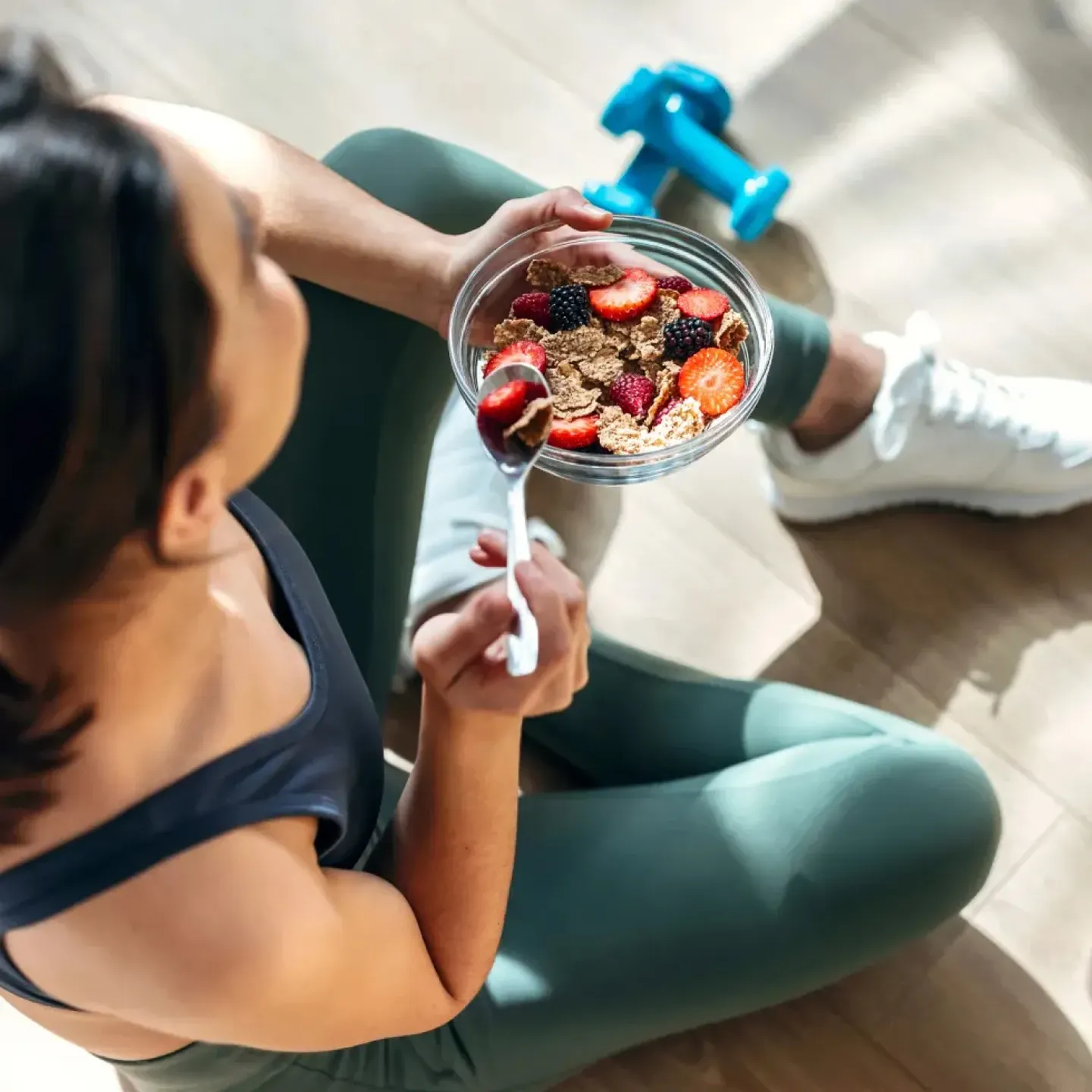 Woman in exercise clothes eating foods to help her joint health.