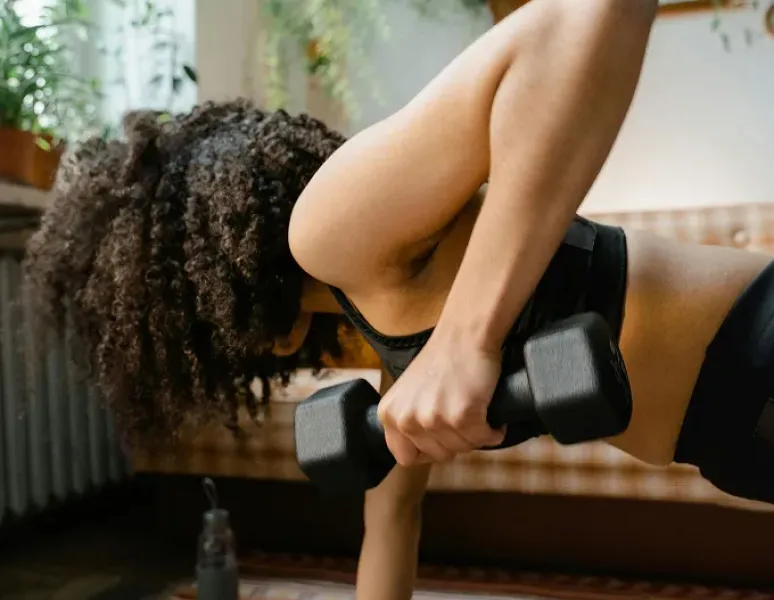 Woman doing strength training with weights represending women's health physical therapy and the 2026 strength training guidelines.