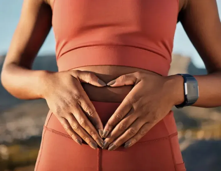 Woman holding her abdomen, representing Origin’s 2026 State of Pelvic health Report.