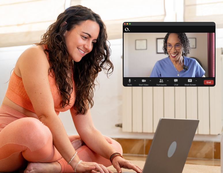 Woman smiling at her computer during a virtual pelvic health physical therapy session with an Origin physical therapist on Zoom