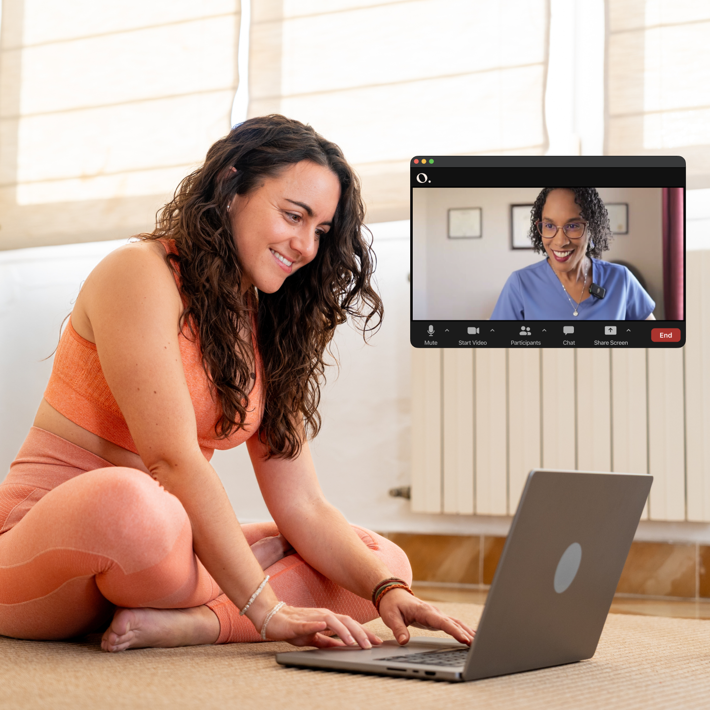 Woman smiling at her computer during a virtual pelvic health physical therapy session with an Origin physical therapist on Zoom