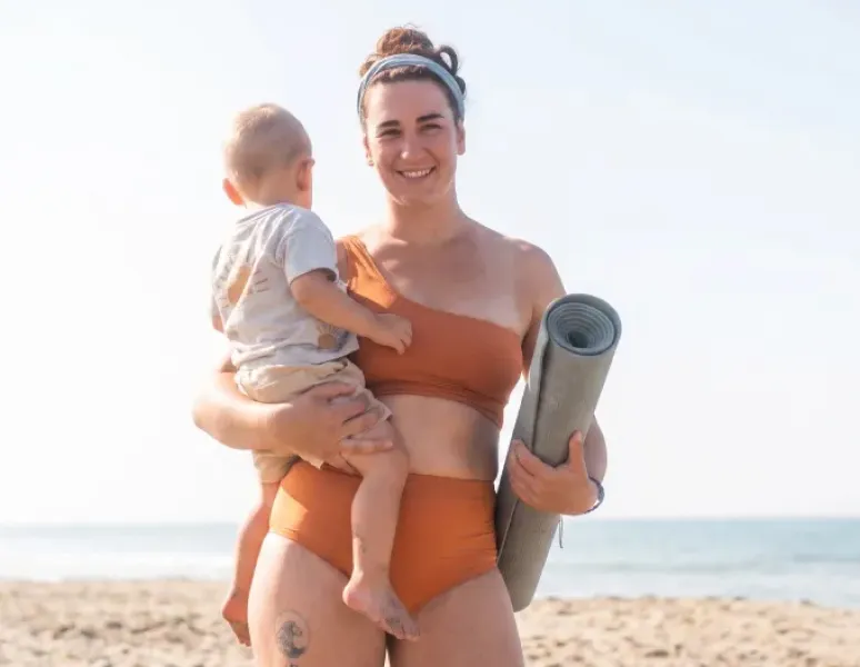 Mujer y su bebé viajando en el verano representando viajes y salud del piso pélvico.