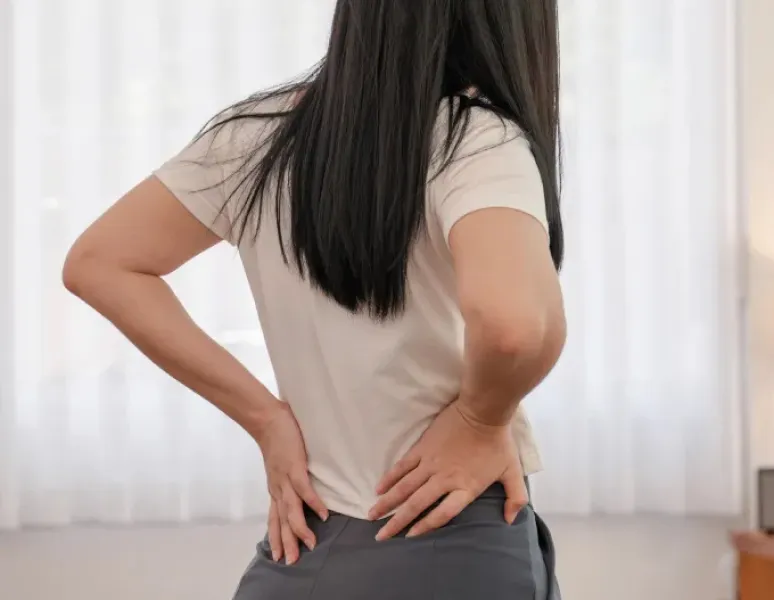 Mujer con dolor de cóccix recibiendo terapia de piso pélvico.