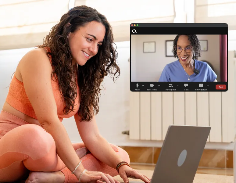 Mujer sonriendo frente a su computadora durante una sesión virtual de fisioterapia de salud pélvica con una fisioterapeuta de Origin por Zoom.