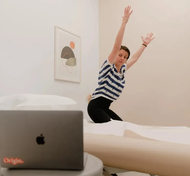 An Origin physical therapist demonstrating an exercise during a virtual visit.