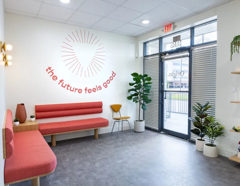 A modern waiting room in Origin clinic, featuring comfortable seating and bright, welcoming decor.
