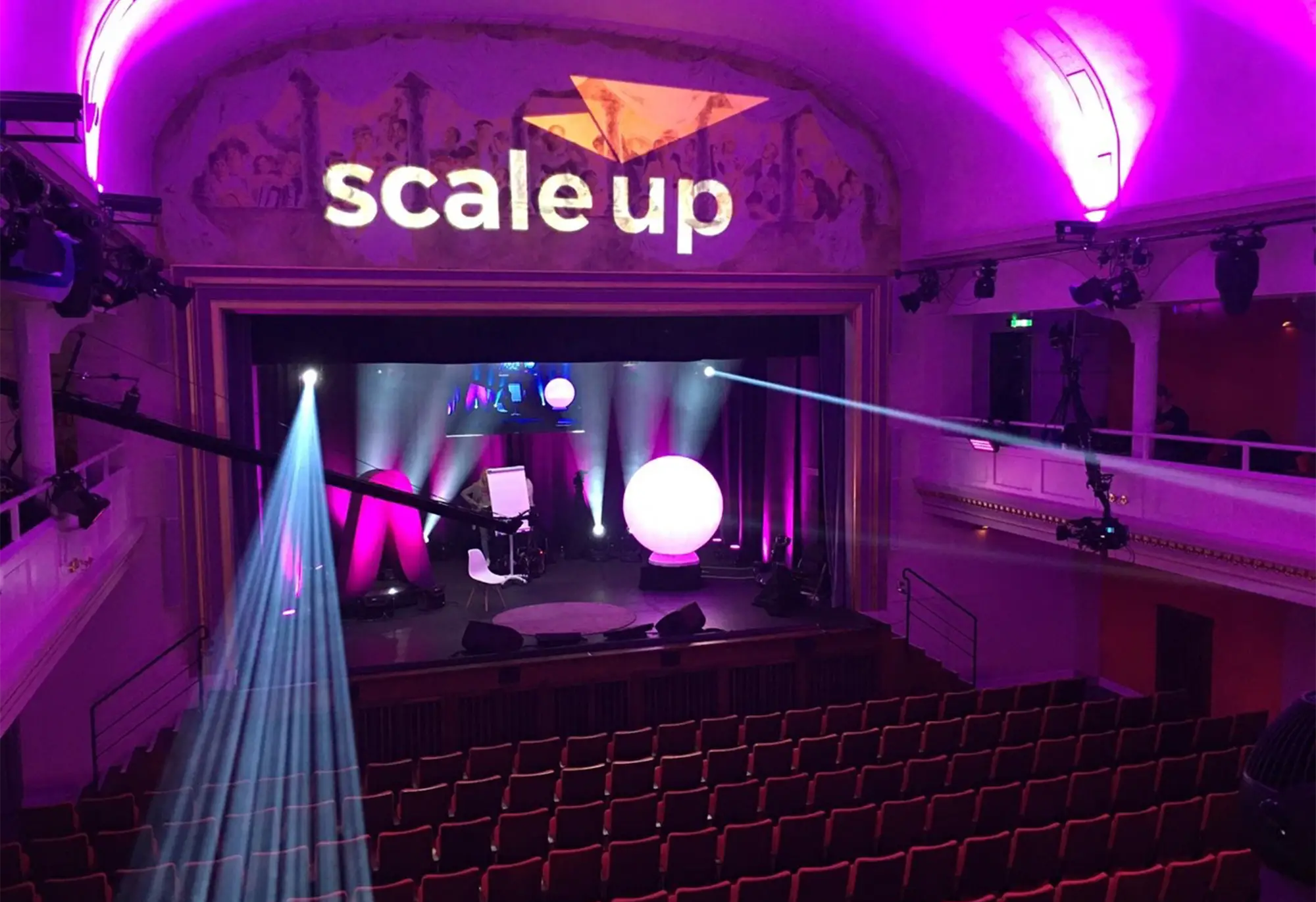 Ein stimmungsvoll beleuchteter Raum eines scale-up Summit-Events.