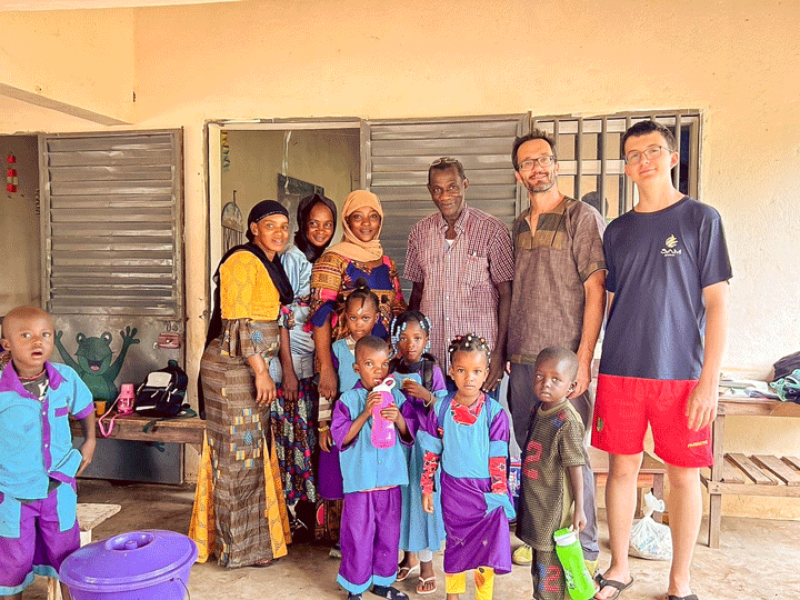 Matthias und Ruven stehen mit ein paar Erwachsenen und Kindern vor einem Haus