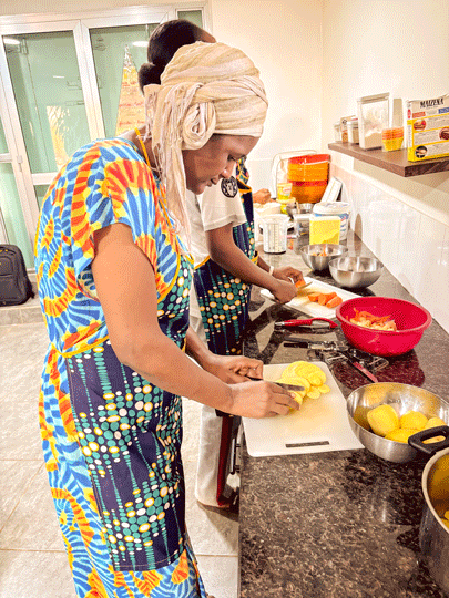 Eine guineische Frau schneidet Kartoffeln