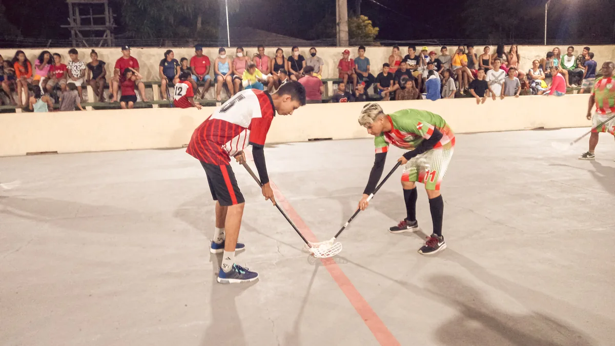 Zwei Floorball-Spieler beim Bully vor vollen Zuschauerrängen