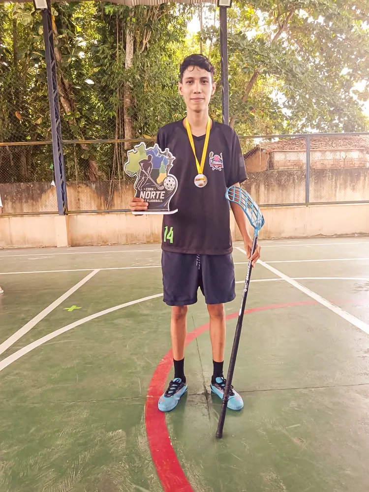 Jardel mit Medaille, Pokal und Floorballschläger auf dem Spielfeld