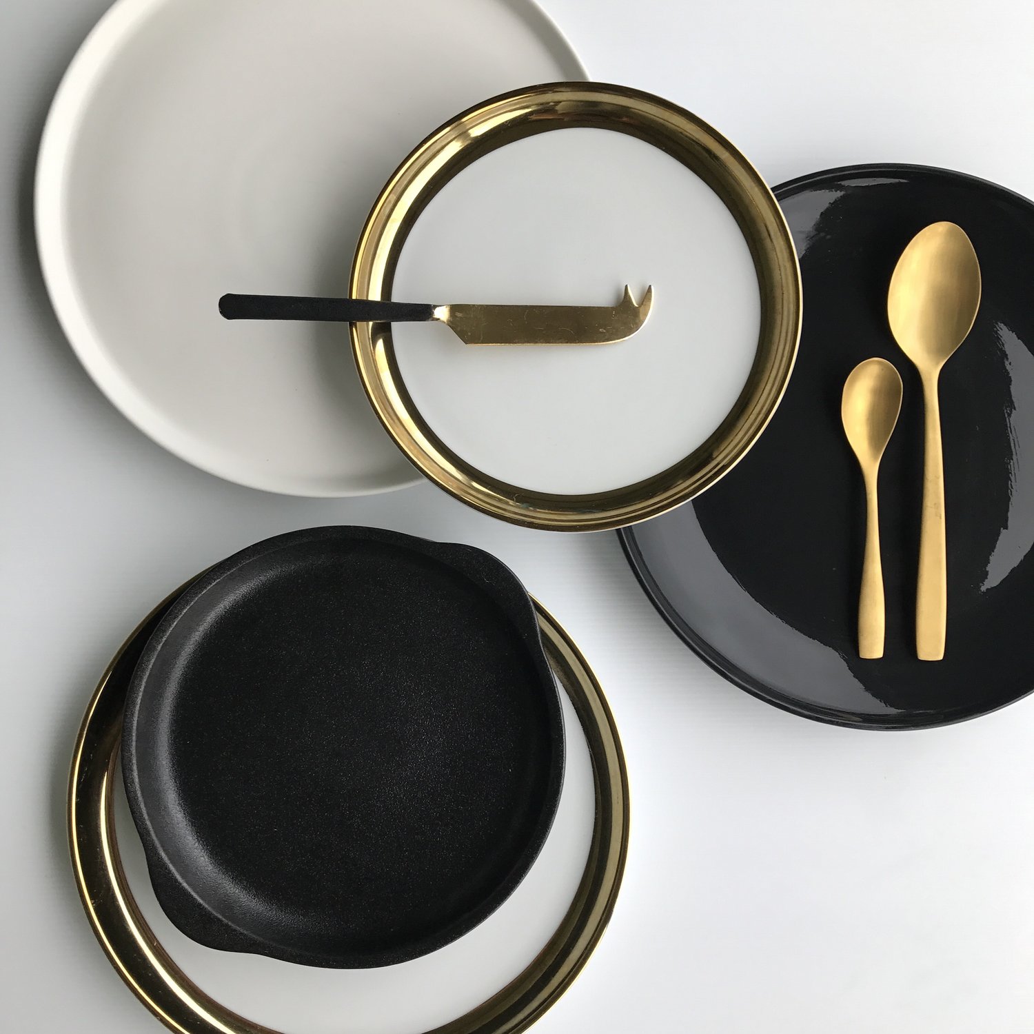 unedited photo of black and white plates and gold cutlery