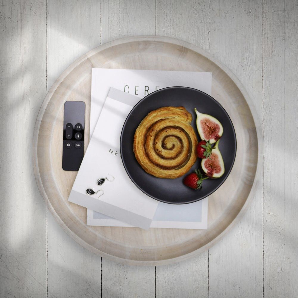 A flatlay of magazines and pastry with a photoshop overlay of a geometric shadow