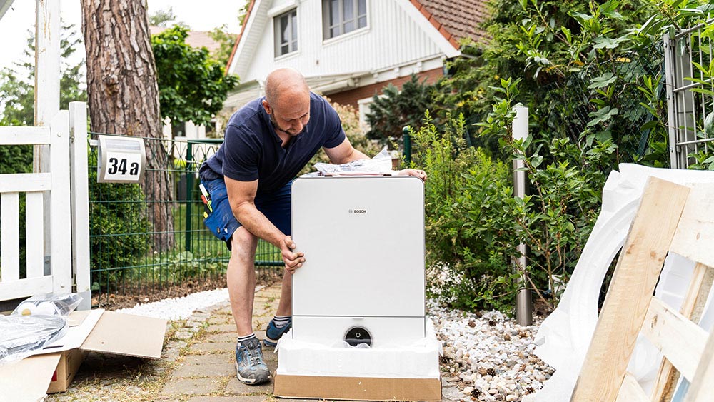Ein Enpal Monteur packt eine Wärmepumpe aus.