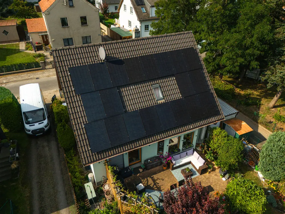 Fertig installierte Enpal Solaranlage auf einem dunklen Hausdach. Aus Vogelperspektive fotografiert.
