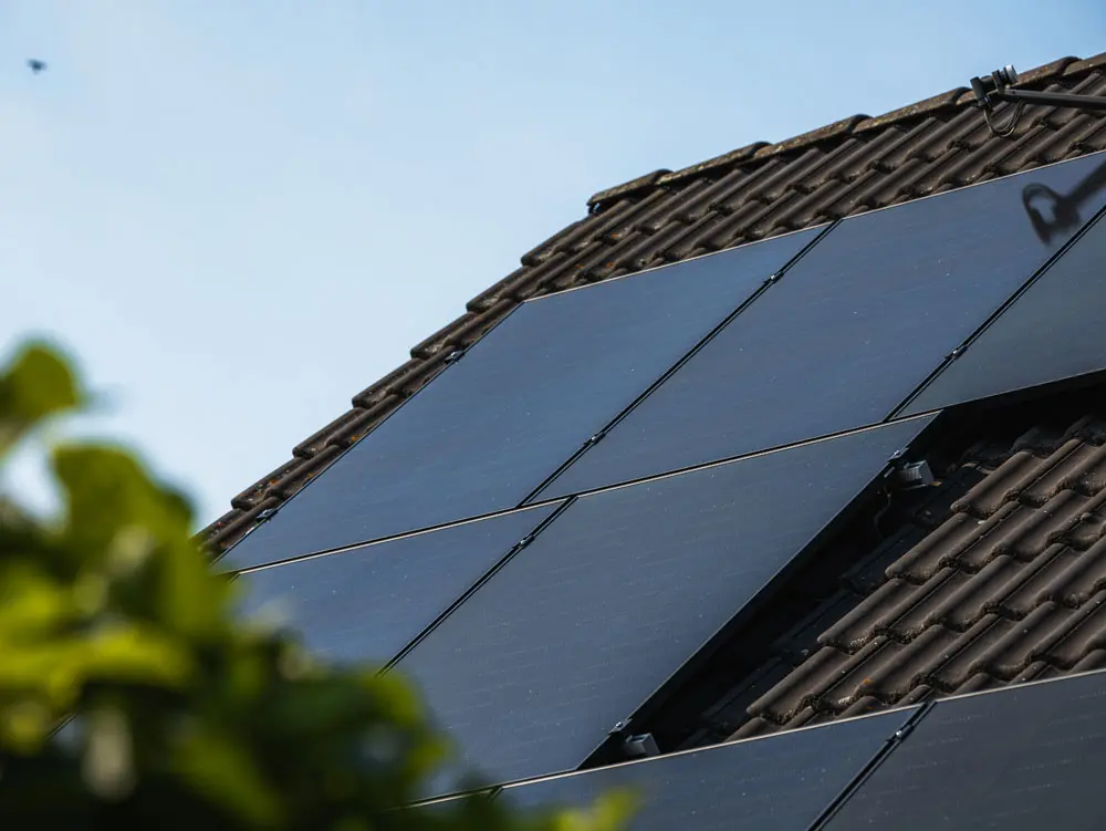 Fertig installierte Enpal Solaranlage auf einem dunklen Hausdach.