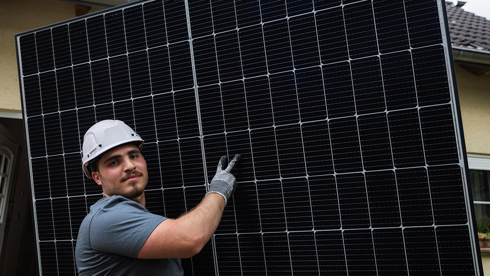 Monteur trägt Enpal Solarmodul