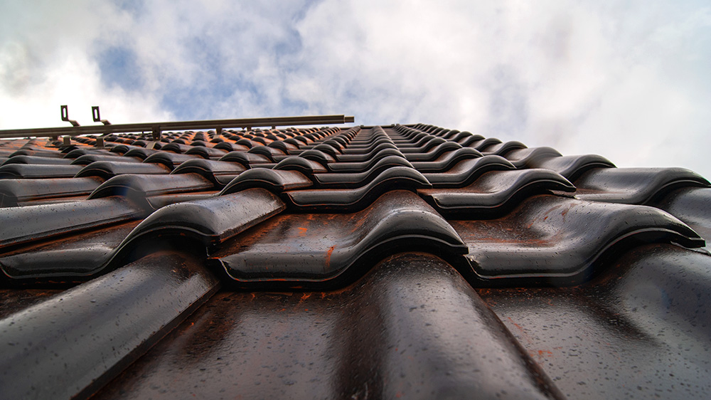 Nahaufnahme von einem Hausdach mit dunkeln Dachziegeln