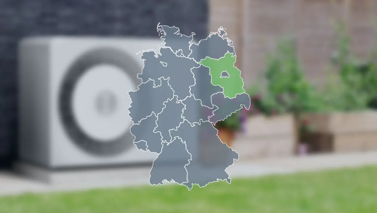 Wärmepumpe verschwommen im Hintergrund und Deutschlandkarte im Vordergrund, wo Brandenburg grün markiert ist, um die Wärmepumpenförderung dort zu zeigen
