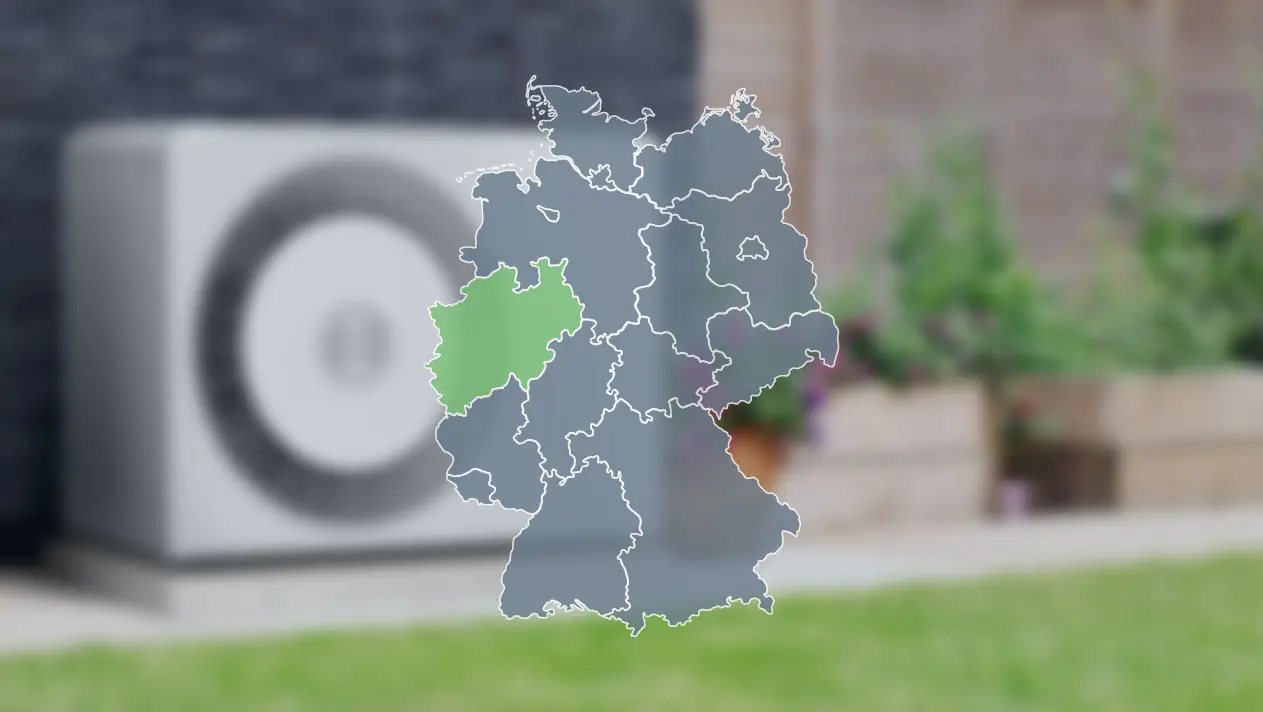 Wärmepumpe verschwommen im Hintergrund und Deutschlandkarte im Vordergrund, wo Nordrhein-Westfalen grün markiert ist, um die Wärmepumpenförderung dort zu zeigen