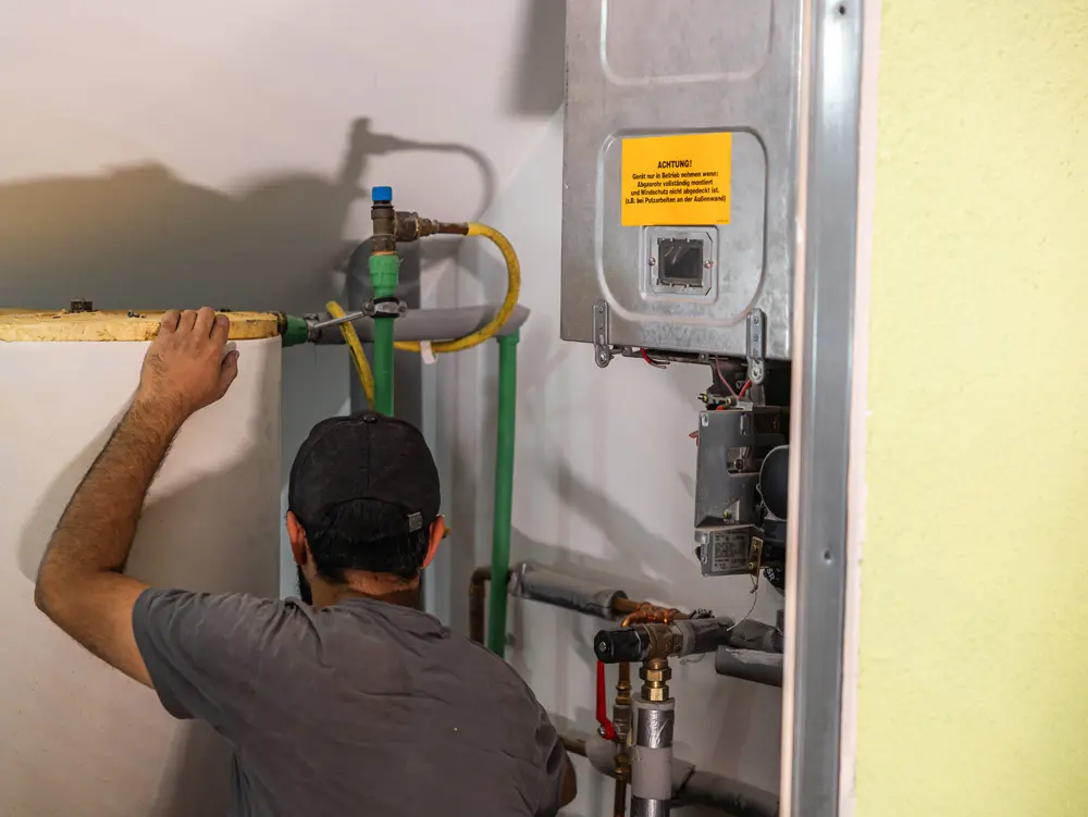 Enpal-Monteur von hinten im Heizungskeller