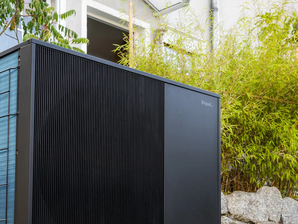 Schräg seitliche Ansicht einer Enpal-Wärmepumpe im Garten