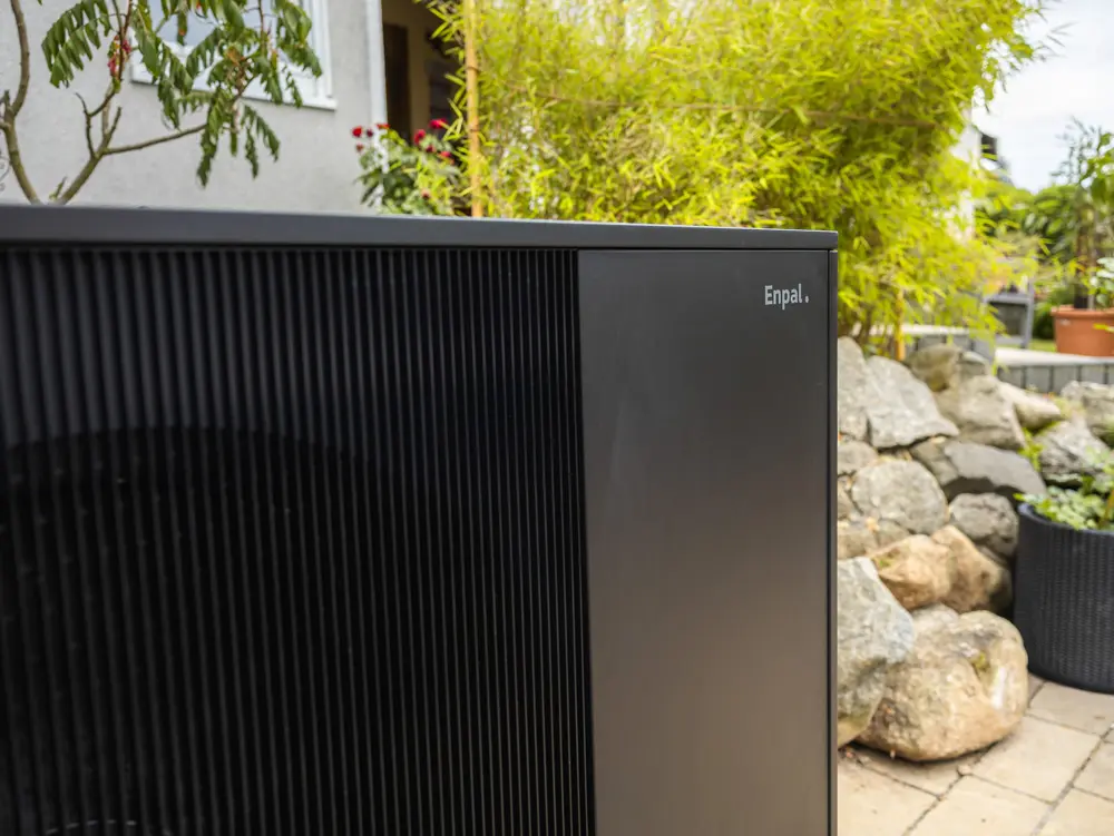 Ausschnitt der Enpal-Wärmepumpe mit Schriftzug im Garten