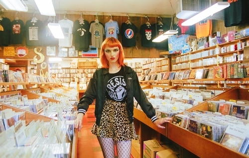 I large picture of a fashion model in a record store for a Wolf Child photoshoot.