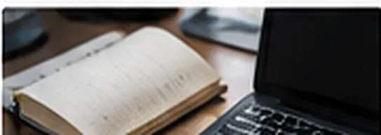 An open notebook beside a laptop on a wooden desk