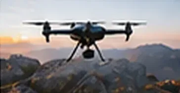 Small drones flying together above a ridge at sunset